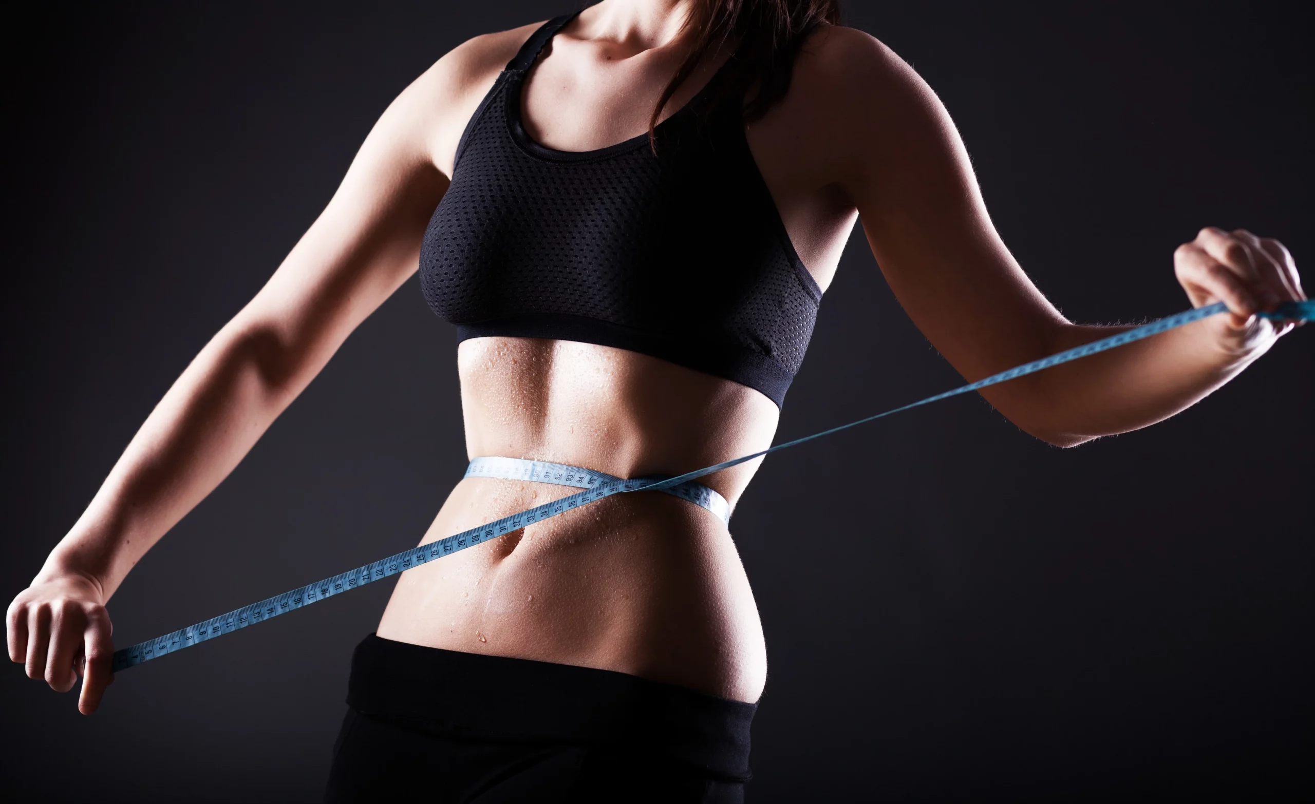 a woman measuring her waist